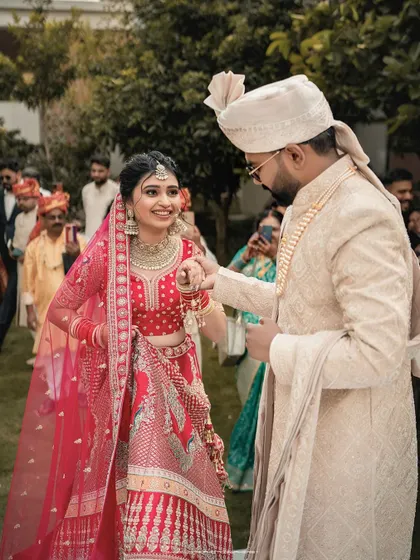 The groom leads his bride, a symbolic and beautiful moment in the wedding ceremony. The focus is on their connection amidst the crowd of loved ones.