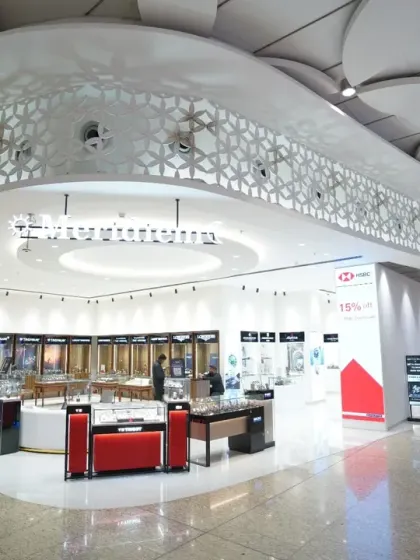 The clean lines and modern architecture of a luxury watch and jewelry store. This wide shot emphasizes the store's design, from the curved ceilings to the strategic placement of display cases.