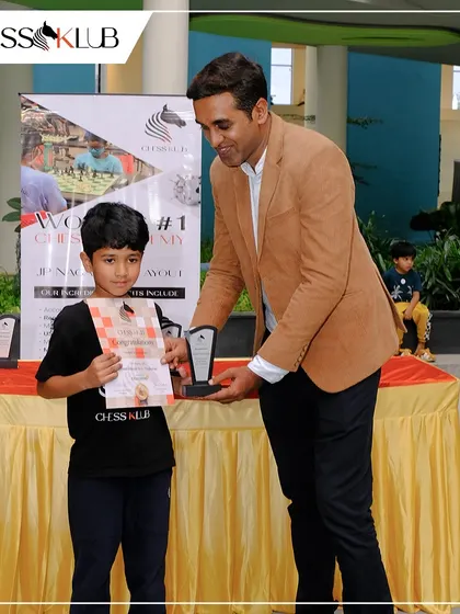 A young player is presented with his certificate and award. Every participant gets recognized for their effort and sportsmanship at our community chess events.