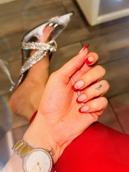 This look is all about coordinating your style. Here, a sharp red French tip on a short, natural-shaped nail perfectly complements a bold red outfit and sparkling heels.
