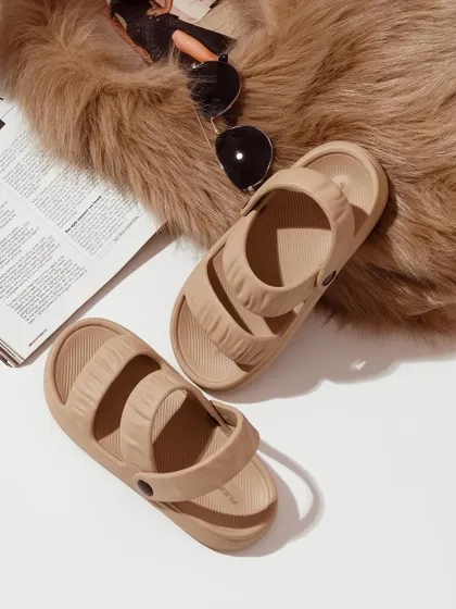 A flat-lay composition featuring beige sandals, a magazine, and sunglasses on a faux fur rug. This type of styling creates a complete aesthetic, selling a lifestyle, not just a product.