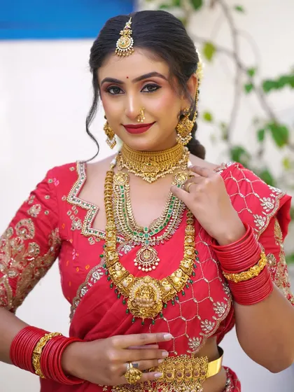 A close-up portrait focusing on the rich temple jewellery and the perfectly matched makeup. The look is traditional, regal, and timeless.