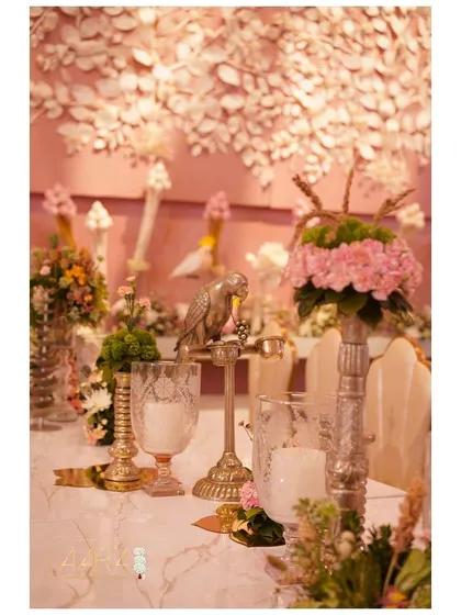 A peek into our expansive pastel pink dining setup. This close-up shows the little details, like the silver parrot figurine and textured glassware, that bring the tablescape to life.