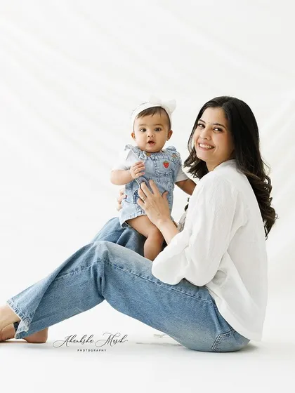 A relaxed and happy mother and daughter portrait. The simple white backdrop and casual clothing allow their genuine connection to be the star of the photo.