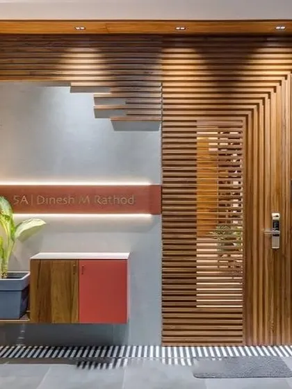 This stunning modern entrance features a door and wall covered in geometric wood slats, with integrated lighting that creates a very dramatic and high-end look.