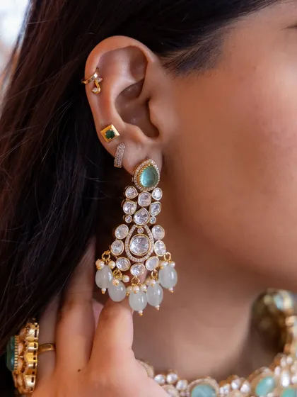 When pearls meet elegance, they create royalty. A close-up of our beautiful bridal earrings, featuring mint green stones, uncut Kundan, and delicate pearl drops.