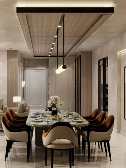 This view of the dining area shows an 8-seater table with plush velvet chairs set under a modern linear light fixture. The design uses a combination of textures and materials to create a refined and elegant dining experience.