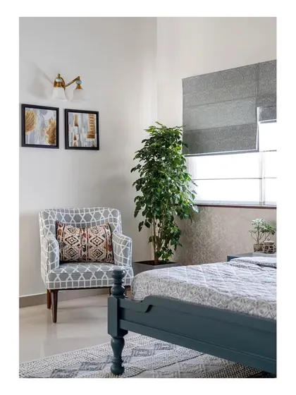 A comfortable lounge chair in the corner of the master bedroom, showcasing the use of layered patterns in the upholstery and rug to add visual interest without overwhelming the serene space.