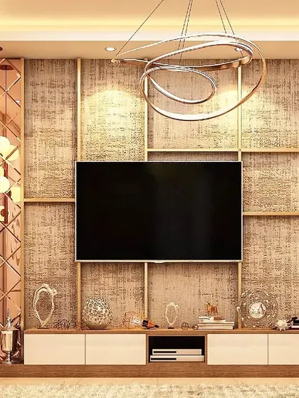 This TV unit features a textured wallpaper backdrop framed by rose-gold mirrored panels with a diamond pattern. The design adds a layer of glamour and reflects light, making the living space feel brighter and more luxurious.