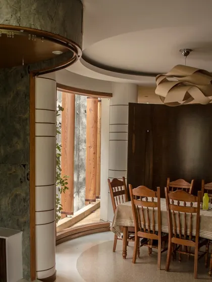 Another view of the dining space, highlighting the use of rich wood tones and green stone to create a warm and sophisticated atmosphere.