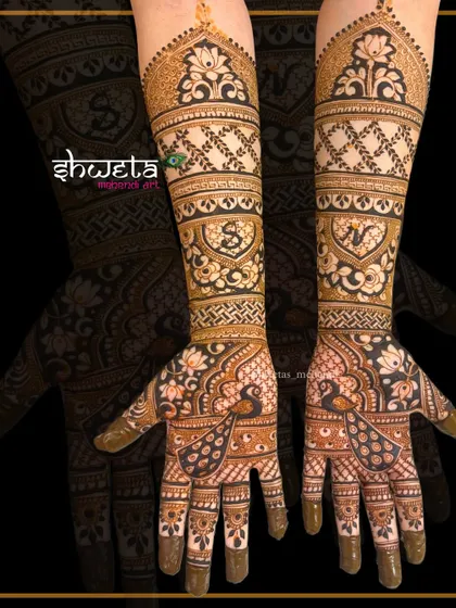 Personalize your mehendi with initials. This traditional design incorporates the couple's initials within heart shapes, surrounded by peacock and lotus patterns.