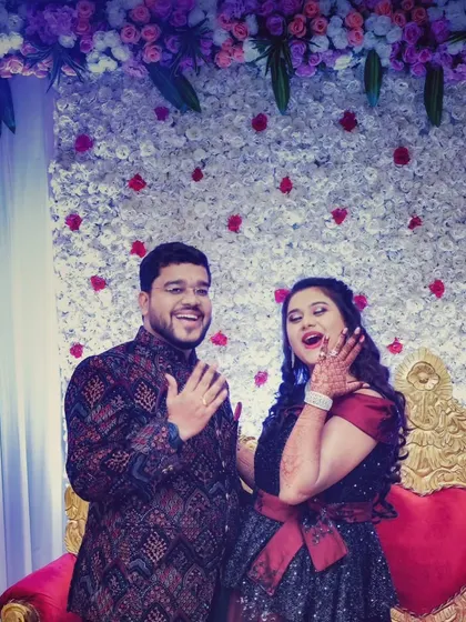 A fun, candid moment where the couple joyfully shows off their new engagement rings to the camera.