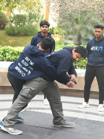 In this outdoor training scenario, we're drilling a defense against a rear grab and knife threat. This is about reacting to an ambush, creating space, and addressing the weapon as the primary threat.