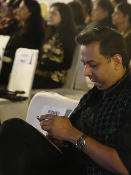 An industry guest and jury member keenly observes the student designs during the show.