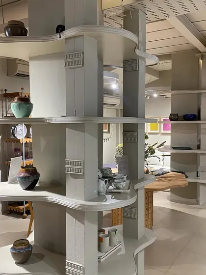 We designed these custom, multi-tiered shelving units to act as functional sculptures within the open-plan space. Their organic, flowing shelves provide a unique way to display smaller decor items and pottery, breaking up the vertical space and adding visual interest.