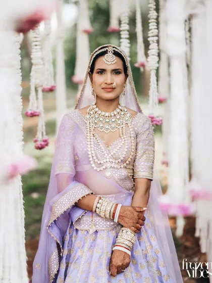 The bride framed by hanging floral decorations. This composition adds depth and a touch of romance to the portrait.