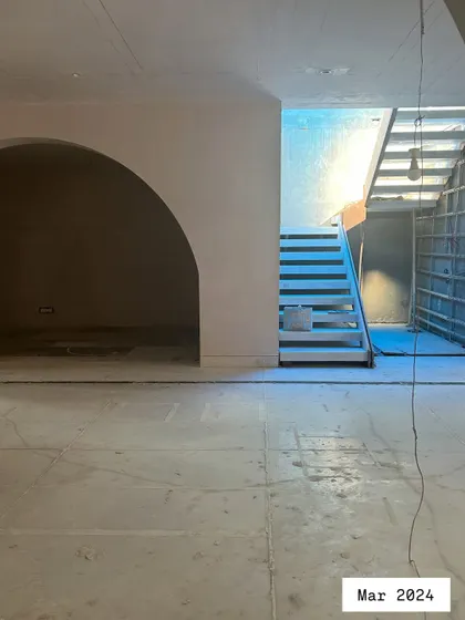 The process begins with a blank canvas. This was the living area of the Quiet Ornate home in March 2024, a raw space full of potential, with the basic structure of the archway and staircase in place.