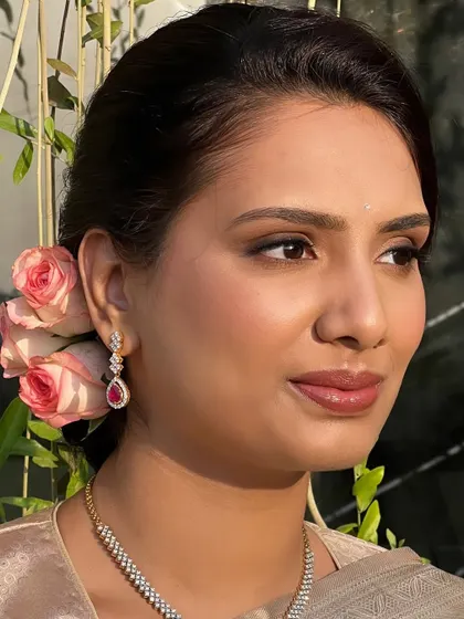 A simple, elegant look that highlights the client's natural beauty. The soft makeup and fresh roses in her hair create a look of timeless romance.