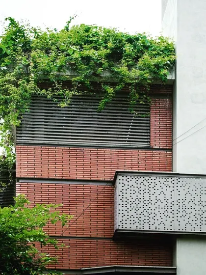 A close-up of the facade of my 'Jenu Goodu' (Beehive) project. The design combines the warmth of brick with the precision of metal louvers and the wildness of a rooftop garden, showcasing a rich material palette.