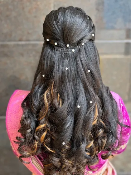 The back view of a half-updo with a braided detail at the crown. I added pearl accents throughout the curls for a touch of classic elegance.
