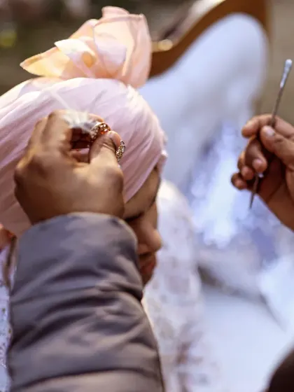 A detailed shot of the groom's 'sehra' being tied, a significant and traditional moment before the main ceremony.