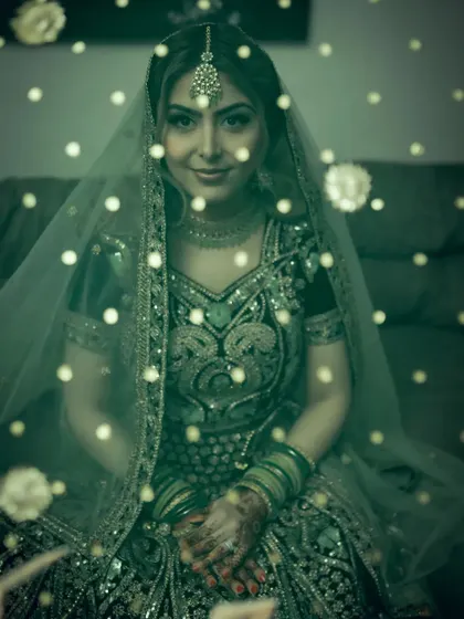 An ethereal portrait of a bride seen through a green-tinted, sparkling veil. The creative lighting and color grading give this image a dreamy, almost magical quality.