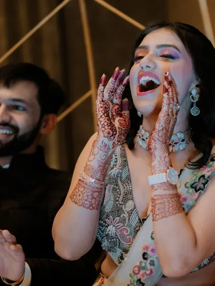 A moment of pure, uninhibited joy as the bride cheers and laughs during her Sangeet night.