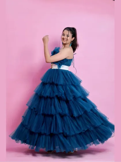 A fun, dynamic pose in the peacock blue gown, showing its movement and playful style.