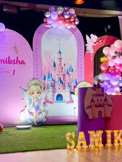 A fairytale castle and butterfly theme for a first birthday. This large-scale setup includes multiple backdrops, a marquee number '1', and marquee letters spelling the name.