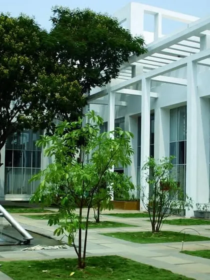 A landscaped courtyard at TCS Yantra Park, featuring a geometric water sculpture and shaded walkways. These outdoor rooms provide tranquil spaces for employees to relax and recharge.