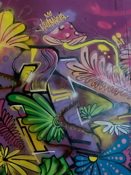 A detail shot of the nature piece, focusing on the mushroom character and the textures of the leaves and flowers.