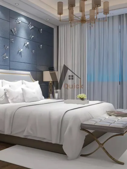 An example of luxury meeting simplicity in bedroom design. A deep blue feature wall with delicate butterfly accents creates a whimsical yet sophisticated focal point. The elegant chandelier and tufted bench add a timeless, classic touch.