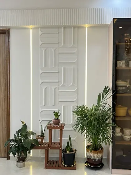 Detail of the entryway, where a stylish door, curated plants, and an elegant glass crockery unit come together to create a warm welcome.