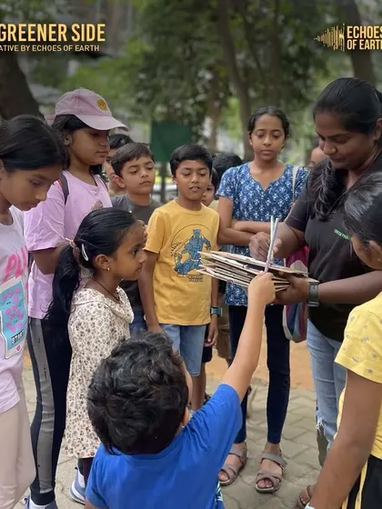 An instructor helps children with their journals during a nature journaling event. These sessions are guided to help kids develop their observation and documentation skills.