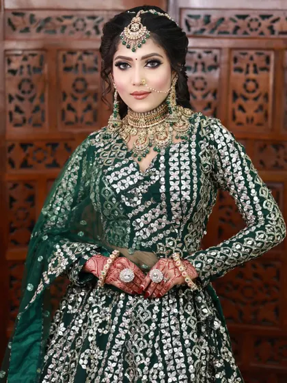 A full look at the bride with the emerald green makeup. The eye makeup is the centerpiece, tying the whole look together with her green outfit and jewelry.