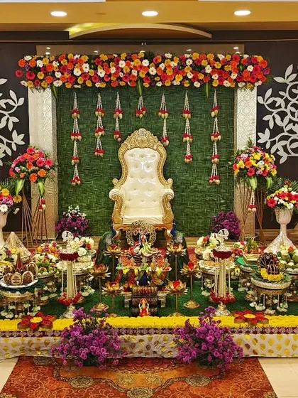 A half-saree function setup with a green backdrop, swan figures, and a tree-of-life motif, creating a serene and symbolic atmosphere.