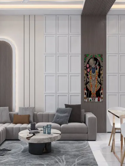 In this living room, we blended contemporary design with traditional Indian art. The walls feature a sophisticated combination of fluted panels and classic moulding, creating a textured backdrop for the serene Shrinathji painting. This space demonstrates our ability to create modern homes that honor cultural heritage and provide a sense of peace.