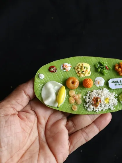 Holding a personalized South Indian meal magnet, a perfect and memorable gift for weddings or other special occasions.