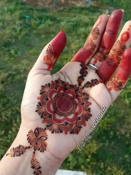 A close-up of a floral mandala design after the henna paste has been removed. The bright orange stain will darken over 48 hours to a deep reddish-brown.