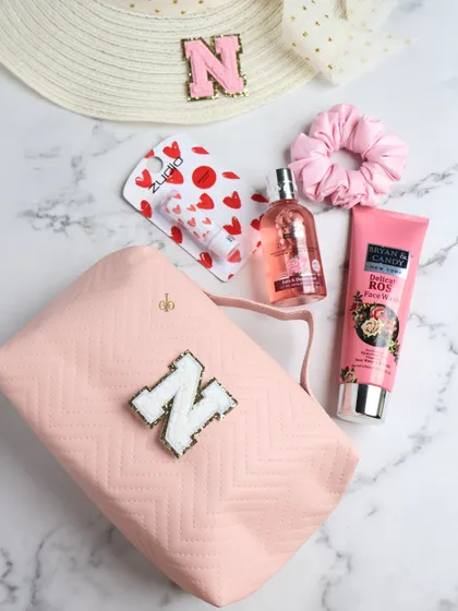 This personalized utility pouch in a soft pink is perfect for organizing your daily essentials. The monogrammed initial adds a personal touch, and it's spacious enough for makeup, skincare, and a matching hat.