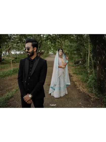 An artistic shot with the groom in the foreground and the bride in the background, playing with focus and depth to create a unique portrait.