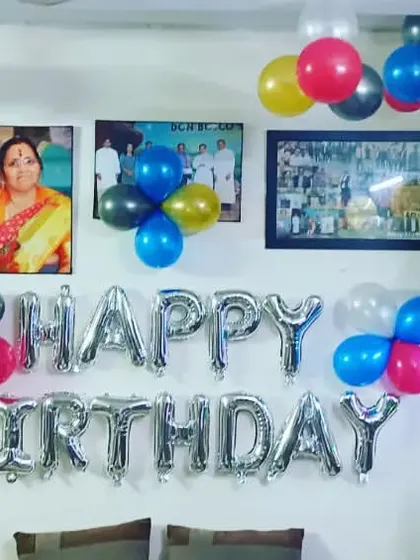 A simple and colorful home birthday setup. We used multi-colored balloons and a silver "HAPPY BIRTHDAY" banner to create a festive corner in the living room, right around the family photos.