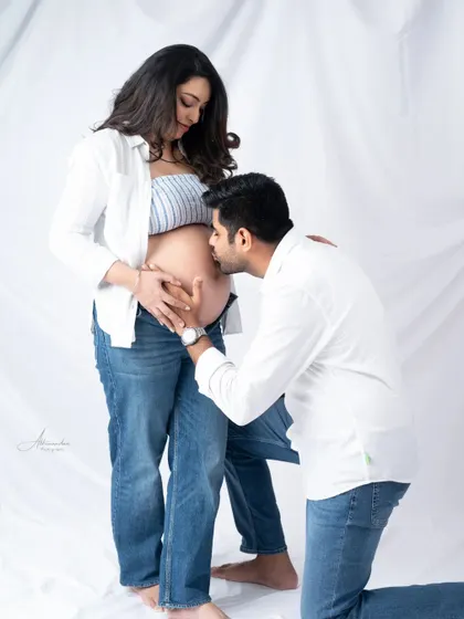 A sweet kiss for the baby. This is one of our favorite poses, capturing the dad-to-be's love for his unborn child.