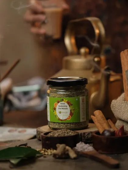A cozy scene featuring a jar of chai masala next to a traditional kettle and a cup of tea. This setup tells a story of a relaxing tea time ritual.