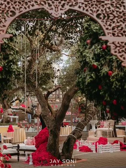Looking through the intricately carved wooden arch, this view frames the beautiful Mehfil-e-Mehendi setup, creating a sense of discovery and anticipation.