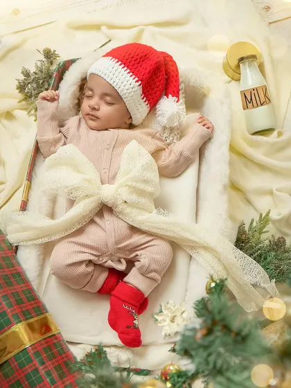 The perfect little Christmas present, tied with a bow. This creative newborn shot is a beautiful and artistic way to celebrate a baby's first holiday season.