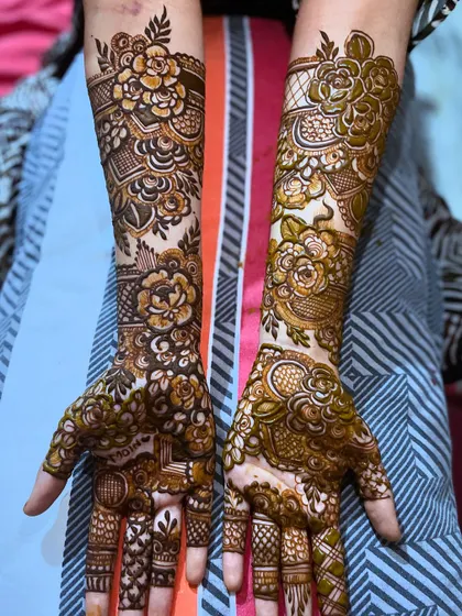 This floral design includes the groom's name, Moin, hidden within the patterns on the palm. It's a sweet and personal secret for the bride to cherish.