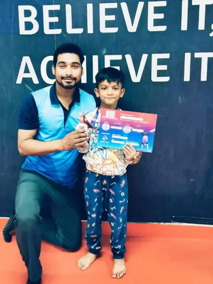 A proud student with his certificate and medal, celebrating his hard-earned victory.