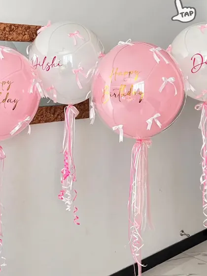 We're loving the bow trend. These personalized pink and white bubble balloons are decorated with tiny bows and long, flowing ribbons for a delicate and feminine look.