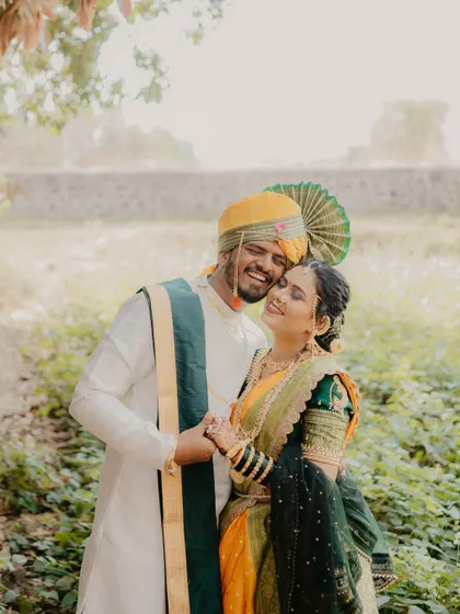 A sweet and joyful embrace. The couple's radiant smiles and the natural, rustic background create a warm and authentic portrait of their love.